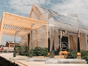 Fachada de la casa Barraca, con su cubierta fotovoltaica inclinada, pérgola de madera y jardineras.