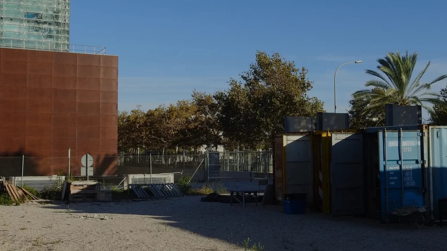 Contenedores marítimos apilados en el solar de Veïnat, preparados para la construcción modular.
