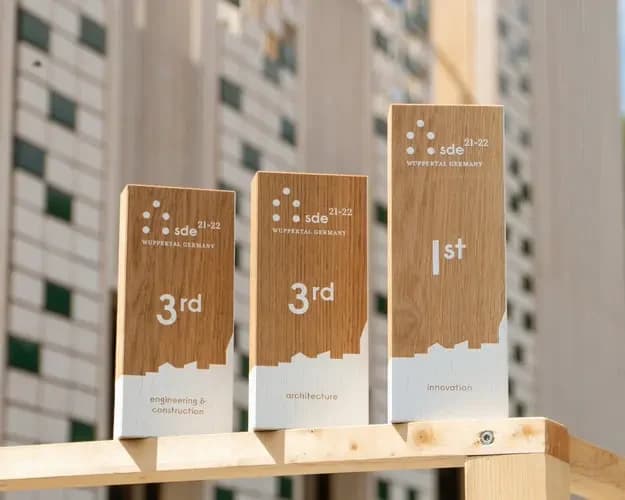 Fachada de Escalà, con revestimiento de madera, cubierta fotovoltaica y terraza con jardineras de lavanda.